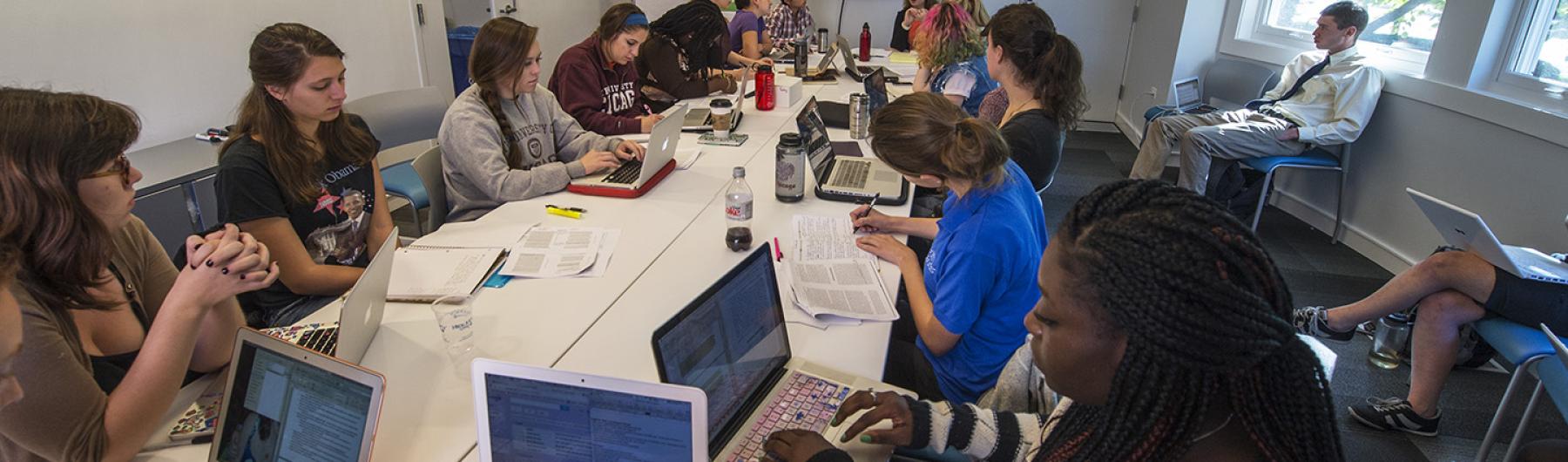 People seated at a table with laptops.