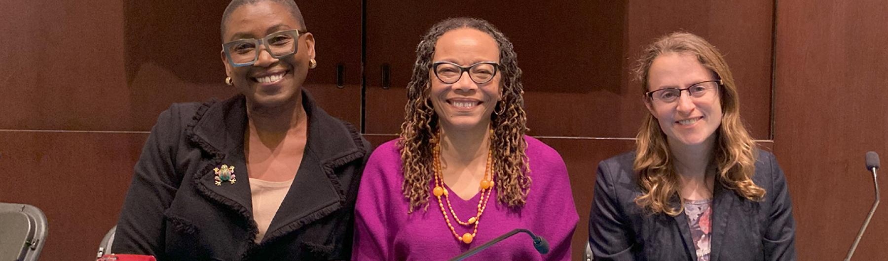 Three poeple smiling at the camera.