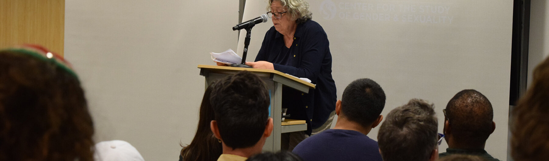 People seated listening to a speaker.
