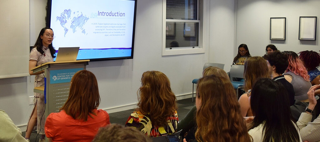 People seated listening to a speaker and looking at a presentation.